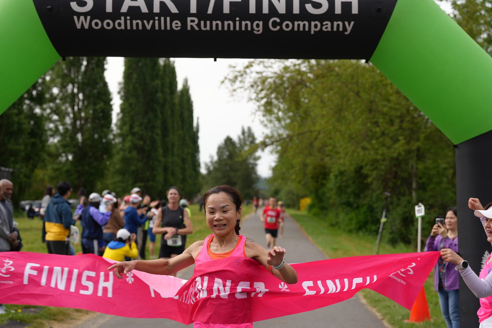 A runner breaking the finish tape at the 2026 Seattle United 5K